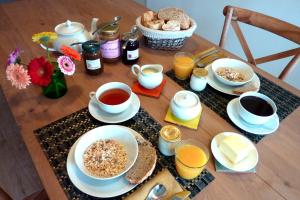 a wooden table with breakfast foods and drinks on it at Chambre d'hôtes Chalendeix in Nedde