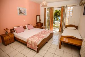 a bedroom with two beds and a balcony at Myros Studios in Argostoli