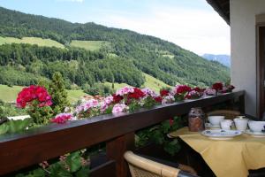 einen Balkon mit einem Tisch und Blick auf die Blumen in der Unterkunft Haus Angerbichl in Ramsau bei Berchtesgaden