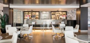 a restaurant with white chairs and tables and a bar at Ilunion Calas de Conil in Conil de la Frontera