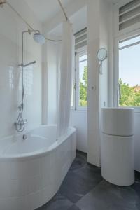 biała łazienka z wanną i prysznicem w obiekcie Baixa24 - Downtown Bliss w/ Amazing Natural Light w Porto