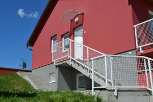a red building with white stairs on it at Villa Venezia in Egerszalók