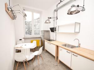 a kitchen with a table and chairs and a sink at Loft Lot Pszczoły in Warsaw +25 photos
