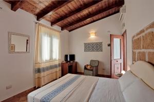 a bedroom with a bed and a tv and a window at Agriturismo Casale Degli Ulivi Alghero in Santa Maria la Palma +37 photos
