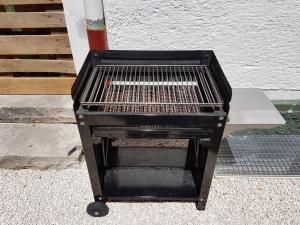 a black barbecue grill sitting on the side of a building at Ferienwohnung ALPENRAUSCH in Kiefersfelden