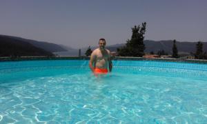 a man is standing in a swimming pool at Safi in Dospat