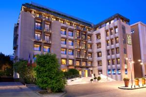 a large building with a tree in front of it at Lazart Hotel, Trademark Collection by Wyndham in Thessaloniki