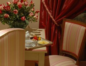 a table with a plate of fruit and a vase with flowers at Hotel Splendid in Cannes