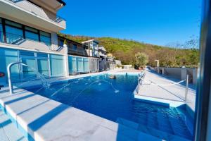 a swimming pool in front of a house at Vea Resort Hotel in Mercato San Severino