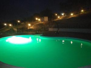 a swimming pool with green illumination at night at Ca Dell'Aglio in Momperone