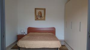 ロゼート・デッリ・アブルッツィにあるDonizetti Apartment 4のベッドルーム1室(ベッド1台付)が備わります。壁に絵が飾られています。