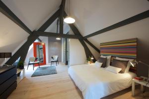 Un dormitorio con una gran cama blanca en una habitación. en Château de Baylac, en Bugnein