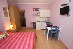 a room with a bed and a table and a kitchen at Apartment Sandi in Vrsar
