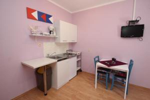 a small kitchen with a sink and a small table at Apartment Sandi in Vrsar +10 photos