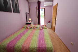 a bedroom with a bed with a colorful bedspread at Apartment Sandi in Vrsar