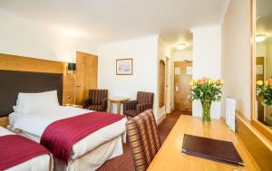 a hotel room with two beds and a table at Three Counties Hotel in Hereford