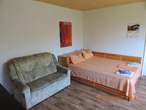 a bedroom with a couch and a bed and a chair at Vila Chasovnikarov in Golden Sands