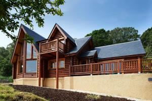 a large wooden house with a large deck at Waterloo lodge in Lochinver