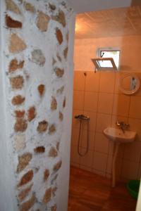 Łazienka z kamienną ścianą obok umywalki w obiekcie Guest House Viola w mieście Ezerets