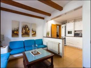 a living room with a blue couch and a table at AGUAIT - Villa approximately aprox 4O OOO meters PLUS PRIVATE mountain approx 3 minutes walking from the beach Ideal for relaxation sport in Port de Pollensa