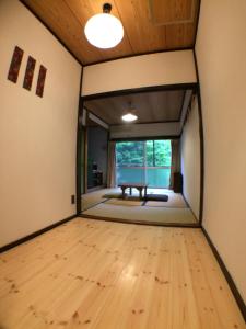 pusty pokój z drewnianą podłogą i oknem w obiekcie Otsu Nature Garden w mieście Akiruno