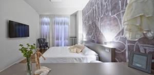 ヴォゲーラにあるSuite Vogue Epocaのベッドと壁が備わるホテルルーム