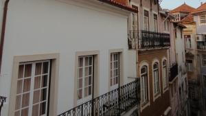 un edificio blanco con ventanas y balcones en BE Coimbra Hostels, en Coímbra