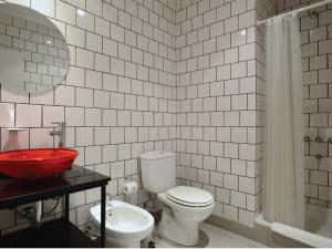 a bathroom with a toilet and a red sink at Velasco House in Buenos Aires