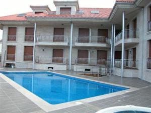 un hotel con piscina di fronte a un edificio di Capricho de Bascuas a Bascuas