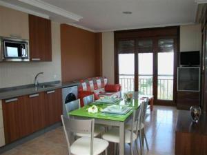 uma cozinha e sala de jantar com mesa e cadeiras em Capricho de Bascuas em Bascuas