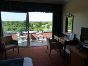 a hotel room with a view of a balcony at London Beach Country Hotel & Golf Club in Tenterden