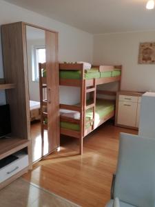 a room with two bunk beds and a mirror at Apartments Milena in Pinezici