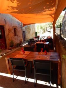 une table et des chaises en bois sous une tente orange dans l'établissement Cafe Vals, à Vals