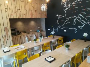 a room with tables and chairs with a map on the wall at Albergue Milladoiro in Milladoiro