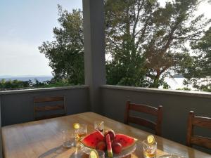 a table with a plate of fruit on top of it at Apartments Jure Miljak in Podstrana