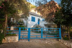 une clôture bleue devant une maison blanche dans l'établissement Apartments Villa Petranović, à Budva