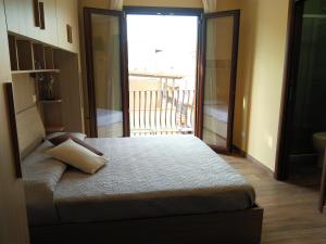 a bedroom with a bed with a view of a balcony at La Maiolica B&B in Balestrate