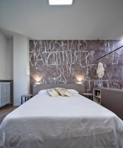 ヴォゲーラにあるSuite Vogue Epocaのベッドルーム1室(壁に落書きが施された白い大型ベッド1台付)