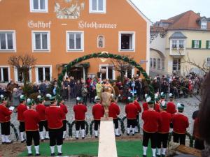 un grupo de hombres con uniformes rojos parados frente a una multitud en Gasthof Stockhammer, en Kelheim