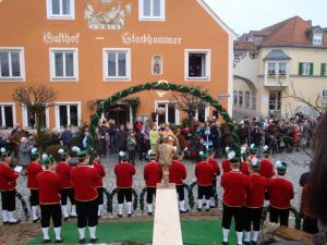 a group of men in red uniforms standing in front of a crowd at Gasthof Stockhammer in Kelheim