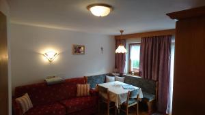 聖卡夏諾的住宿－普樂尼爾公寓，客厅配有红色的沙发和桌子