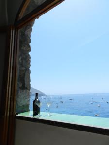 a man standing on a ledge looking out at the ocean at La Dolce Vita a Positano boutique hotel in Positano