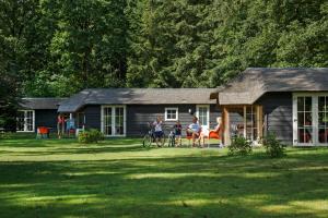 a group of people sitting in front of a cabin at Molecaten Park De Leemkule in Hattem