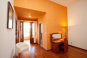 un soggiorno con scrivania e specchio di Hotel Villa Antigua a Sucre