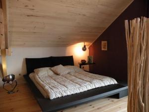 a bedroom with a large bed in a attic at Les Etoiles du Berger in Verrières +38 photos