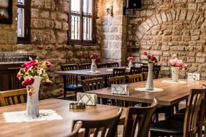 ein Zimmer mit Tischen und Stühlen, auf denen Blumen in Vasen stehen. in der Unterkunft Asamina Boutique Hotel in Tyros