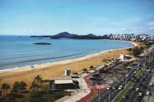 a view of a beach with a road and cars at Slaviero Vitória in Vitória