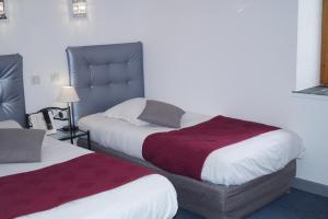 ein Hotelzimmer mit 2 Betten mit roter und weißer Bettwäsche in der Unterkunft Le Val d'Amby in Hières-sur-Amby