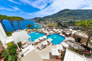 
a beach with lots of palm trees and a large building at San Montano Resort & Spa in Ischia
