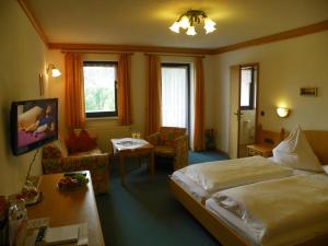 a hotel room with a bed and a table at Landhotel Steigerwaldhaus in Burghaslach